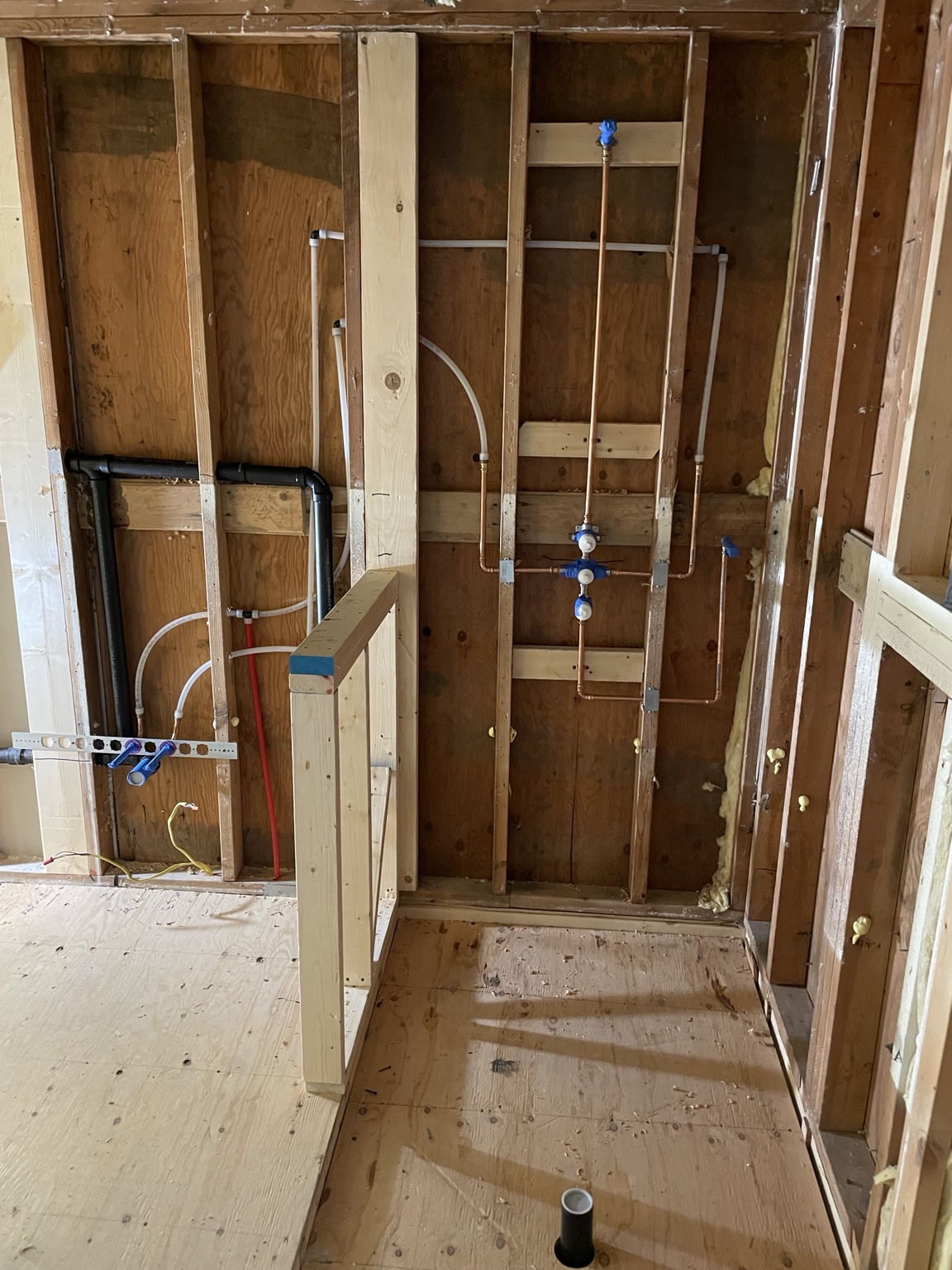 Exposed shower framing and plumbing during a bathroom remodel